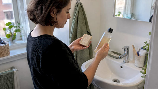 Vrouw vergelijkt vaste zeep met douchegel