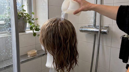 Vrouw brengt zure spoeling aan op nat haar